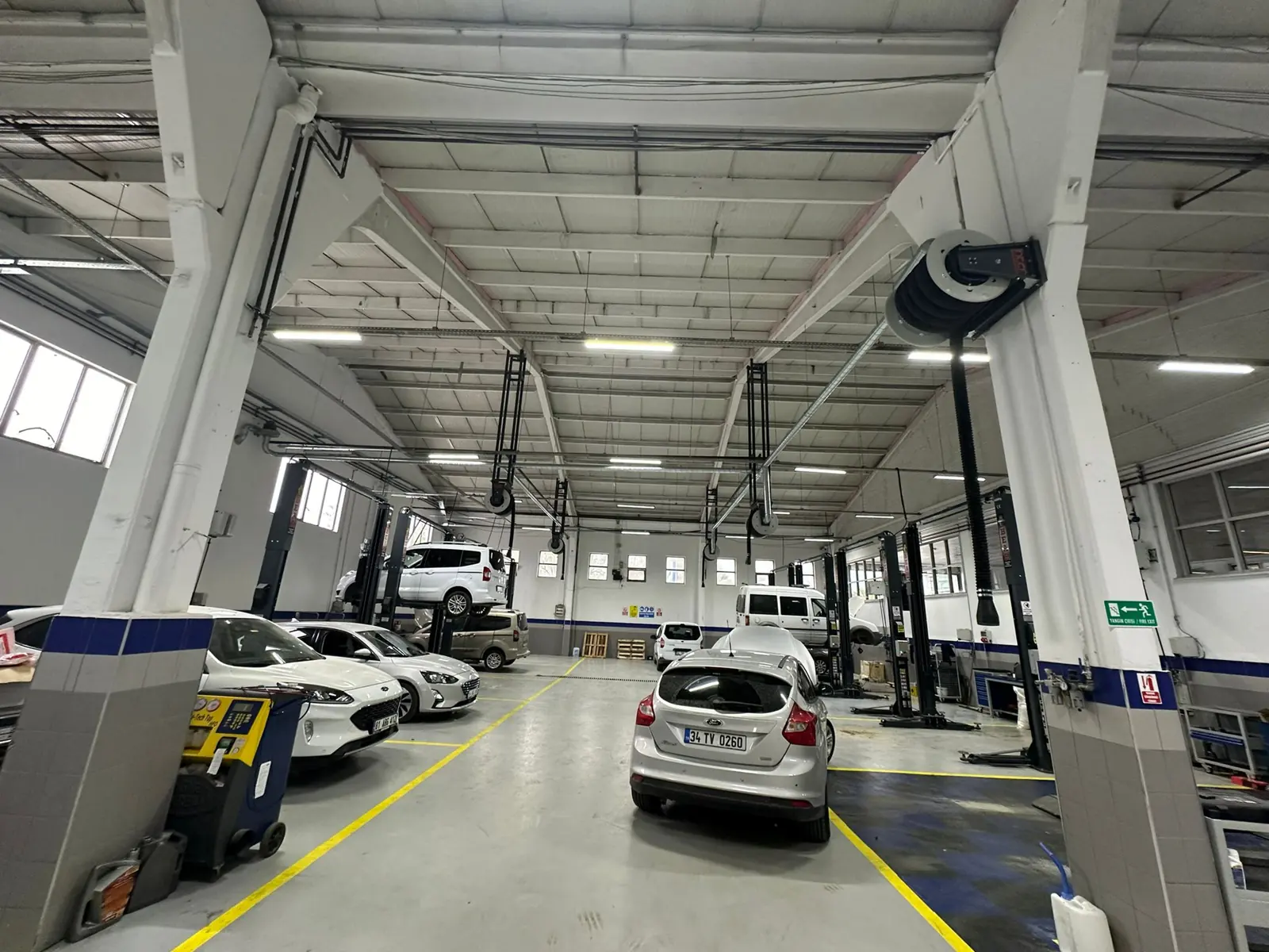 Binek araç servisinde lift başlarına monteli egzoz gazı tahliye makaraları