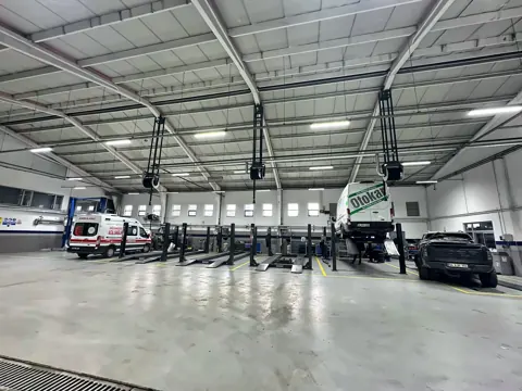 An der Dachkonstruktion montierte Abgasschlauchaufroller in einer großen Servicewerkstatt