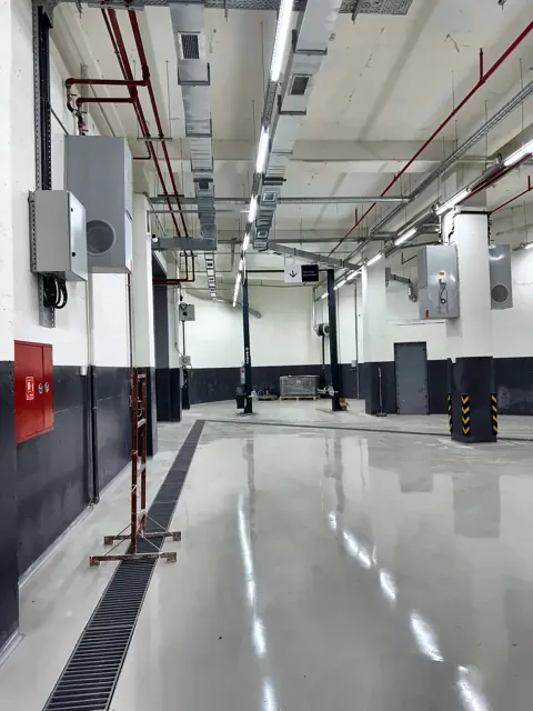 An Säulen montierte Abgasschlauchaufroller und Deckeninstallation in einer neuen Servicewerkstatt