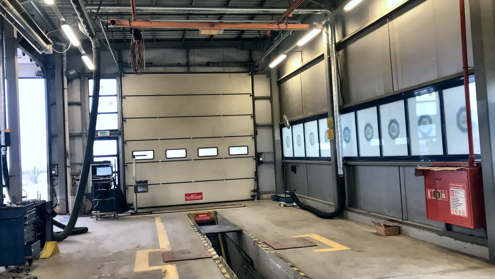 Exhaust extraction hoses on an inspection lane with a pit